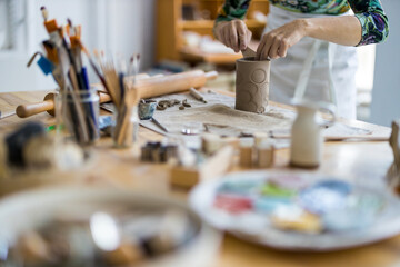 Close-up of craftswoman working on her pottery in workshop
