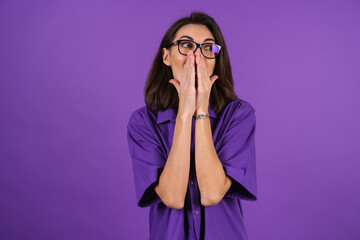 Young woman in a shirt with short sleeves on a purple background, with makeup and stylish glasses,...