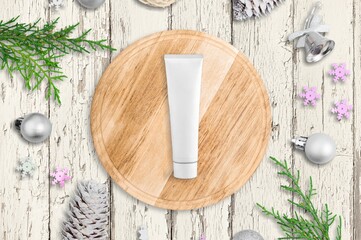 Facial Skincare product tube decorates with Christmas bauble. Cosmetics for festive decoration concept