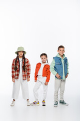 Fototapeta premium full length of happy boy and stylish girls posing on white.