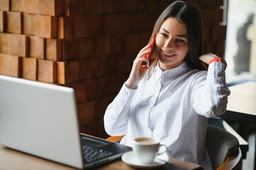 Young woman successful manager is talking via mobile phone with possible financial company employee...