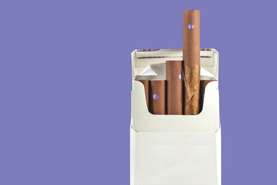 cigarillos pack on purple background copy space