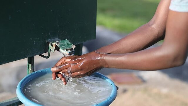 close up of african man is washing his hands outdoors. High quality FullHD footage