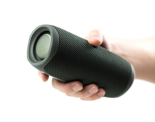 The hand holds a portable wireless speaker. Close up. Isolated on a white background