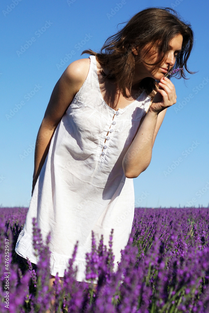 Poster scenic shot of a caucasian short-haired woman wearing a white dress in a lavender field