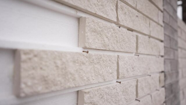 White exterior wall tiles mounted on polystyrene foam. Decorative tiles on the facade of the house.
