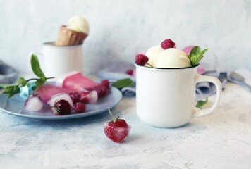 Homemade ice cream watered with fruit syrup and strewn with fresh raspberries and strawberries, ice, on a white table, frozen homemade healthy food, sweet dessert