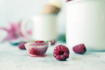 Homemade ice cream watered with fruit syrup and strewn with fresh raspberries and strawberries, ice, on a white table, frozen homemade healthy food, sweet dessert