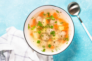 Meatballs soup with vegetables. Traditional Ukrainian dish. Top view on light table.