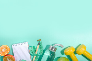 Spring, summer slimming season concept. Sport bottle with water, fitness dumbbells, beach lounger decor, measuring tape, notepad, apple, sliced orange on light blue white background. Flatlay copy spac