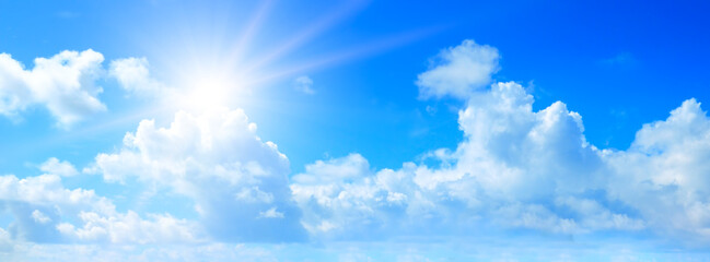Blue sky, sun and clouds. Wide photo.