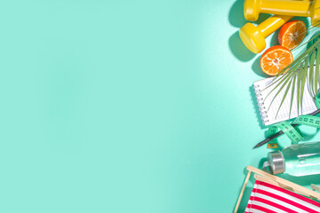 Spring, summer slimming season concept. Sport bottle with water, fitness dumbbells, beach lounger decor, measuring tape, notepad, apple, sliced orange on light blue white background. Flatlay copy spac