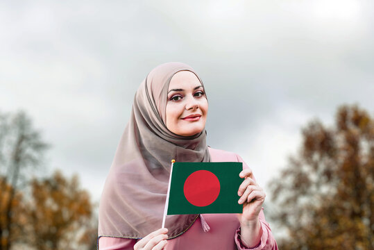 Muslim woman in hijab holds flag of Bangladesh
