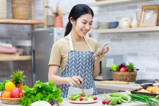 image of asian woman preparing salad in the kitchen