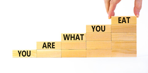 You are what you eat symbol. Wooden blocks with words 'You are what you eat'. Beautiful white background, copy space. Doctor hand. Healthy eating concept. Copy space.