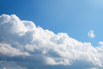 Fototapeta na wymiar Bright blue sky with clouds in sunlight