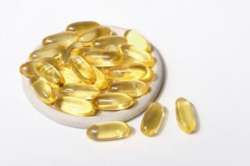 omega-3 capsules on a grey plate. fish oil for vascular health and heart support. essential...