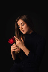 Gorgeous woman gently caress red rose