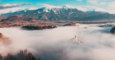 amazing panorama of Lake Bled Blejsko Jezero on a foggy morning with the Pilgrimage Church of the...