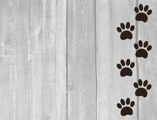 Animal track paw prints on wooden boards texture background with copy space for text and design.

