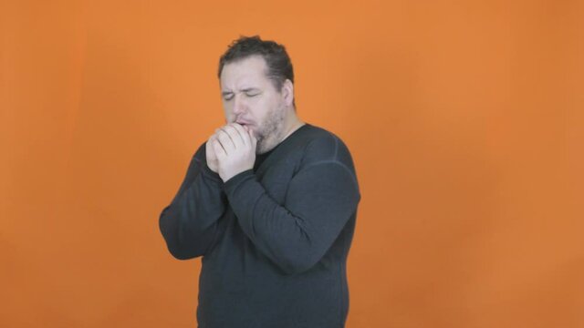 Sick fat man on an orange background.
