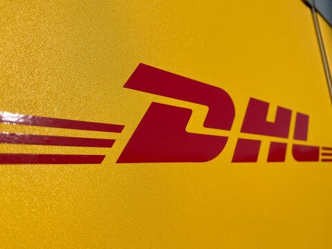 Viersen, Germany - July 9. 2020:  Closeup of dhl logo lettering at yellow parcel collection station (focus on letter D)