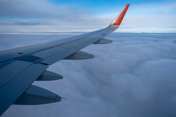 Obraz premium Classic image through aircraft window onto wing. Flight view over clouds