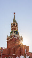 Fototapeta na wymiar Spasskaya Tower of Moscow Kremlin on Red Square, Russia. Blue sky background with sunbeams