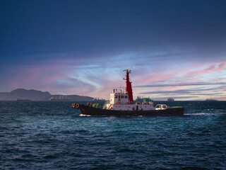 Fototapeta premium Tug boat is sailing to berth after completed assist vessel to alongside.