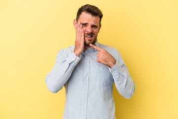 Young caucasian man isolated on yellow background having a strong teeth pain, molar ache.