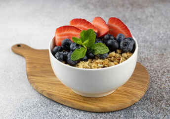 Healthy breakfast: crispy granola with berries on a gray background close-up