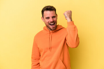Fototapeta premium Young caucasian man isolated on yellow background celebrating a victory, passion and enthusiasm, happy expression.