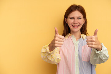Young English woman isolated on yellow background smiling and raising thumb up