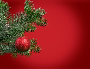 Red Christmas ornament. Bauble hanging on the thread on a red background.