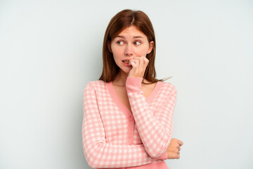 Fototapeta premium Young English woman isolated on blue background biting fingernails, nervous and very anxious.