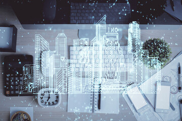 City drawing over computer on the desktop background. Top view. Double exposure. Smart home concept.
