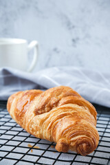 Croissant on baking rack with white background