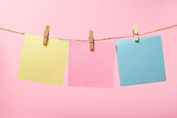 Stickers for notes on a pink background. Colored sticky notes on a string. There is room for copy space