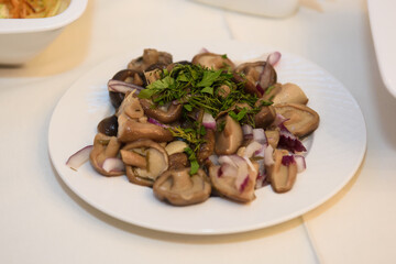 Mushroom salad on the table. A table with food and alcohol served with dishes for guests.
