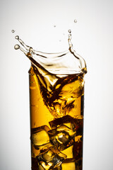 a glass of apple juice on a white background with a splash