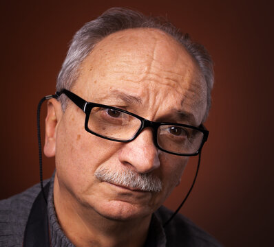Close-up portrait of an elderly man with skeptical expression