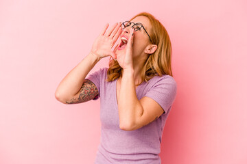 Young caucasian woman isolated on pink background shouting excited to front.