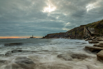 Fototapeta premium A spectacular sunrise at St Mary's Lighthouse in Whitley Bay, as the sky erupts in color