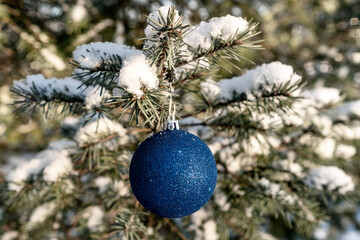 Blue Christmas bauble on a fir-tree branch