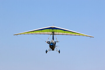 Ultralight airplane flying in a blue sky	