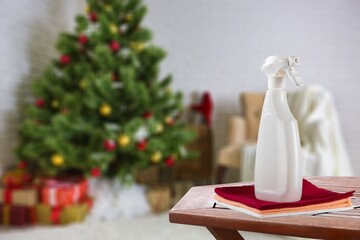 A bottle of detergent against the background of New Year's lights. General professional cleaning before Christmas. Spray disinfection