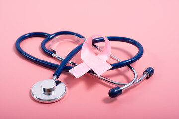 Stethoscope and pink ribbon on pink background as breast cancer awareness symbols