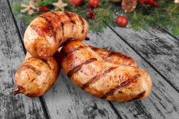 Christmas grilled sausages with spices on a stone background with Christmas trees and Christmas decorations, gifts