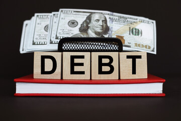 DEBT the word on wooden cubes, Business and finance concept
