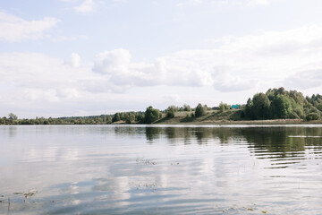 A long fishing rod on the background of the lake. Fishing on a clear summer day on a beautiful lake.